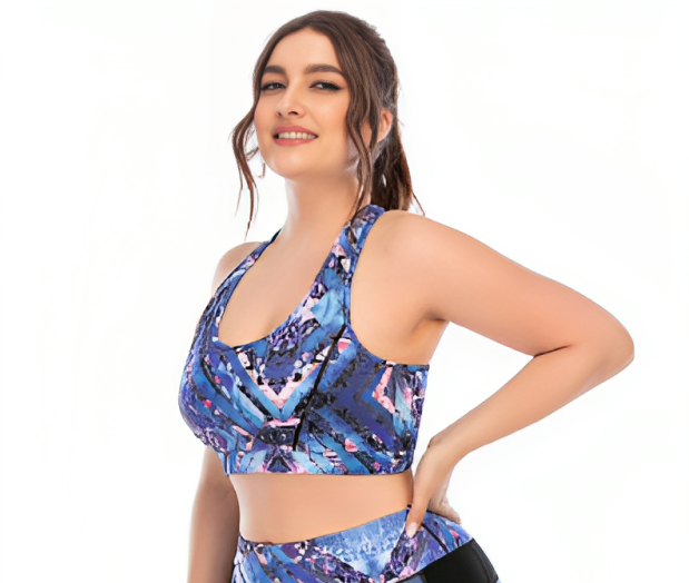 A woman wearing a blue geometric patterned sports bra and matching leggings.