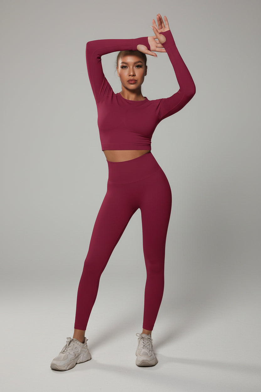 Model wearing a pink athletic outfit posing against a dark background