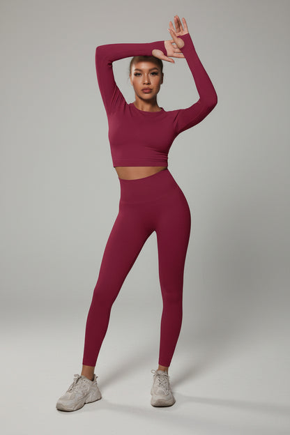 Model wearing a pink athletic outfit posing against a dark background