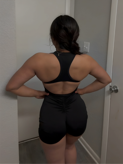 Person wearing a black athletic outfit standing in a room.