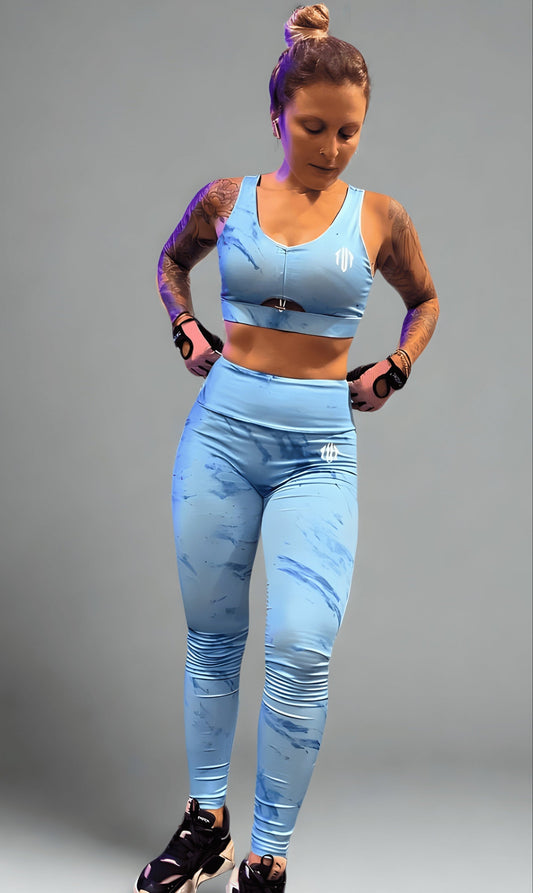 Woman wearing a light blue athletic outfit on a gray background