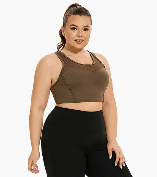 Woman wearing an olive green sports bra and black leggings on a white background