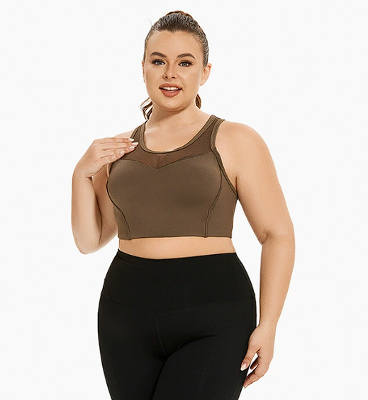 Woman wearing a brown sports bra and black leggings on a white background